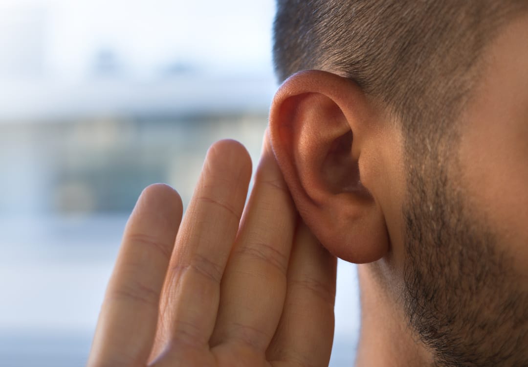 person-holding-a-hand-up-to-their-ear person holding hand up to their ear