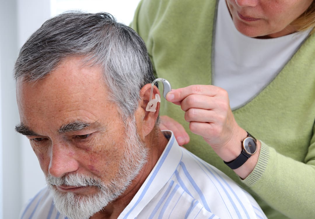 older-person-getting-a-hearing-aid-put-in older person getting a hearing aid put in