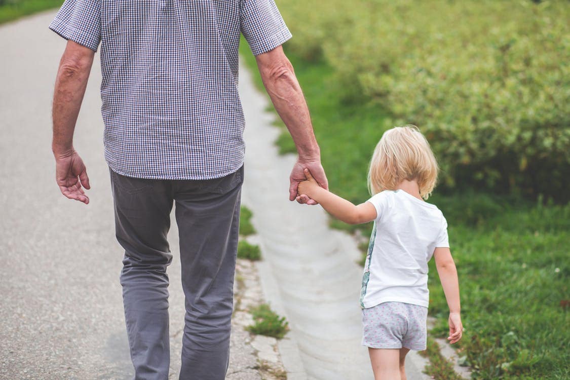 older-person-holding-childs-hand-while-walking older person holding childs hand while walking